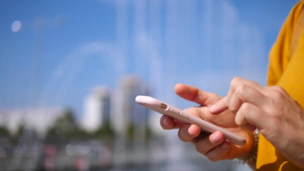 Gros plan de mains de femme utilisant son téléphone portable à l'extérieur . — Video