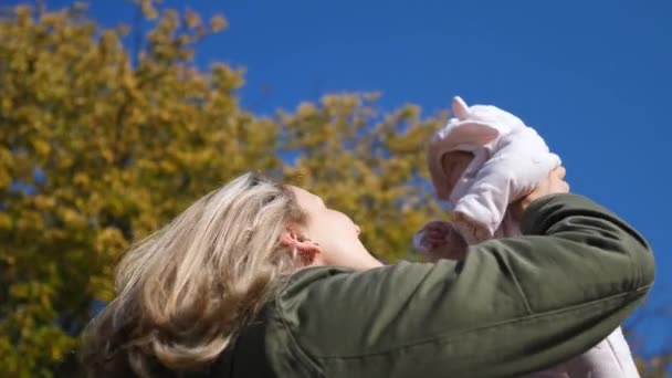 Happy Family Concept. Mère tenant son bébé dans les bras marchant dans le parc . — Video