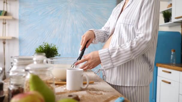 Крупним планом вагітна жінка готує їжу на кухні — стокове відео