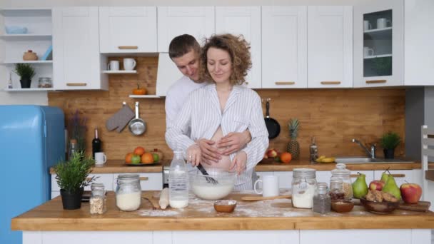 Glückliche Schwangerschaft, Familie, Pflege, gemeinsames Kochen. Schwangere in Küche. — Stockvideo