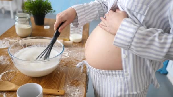 Mujer embarazada prepara una comida en la cocina — Vídeo de stock