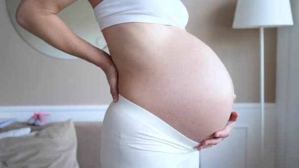 Mujer embarazada que sufre dolor de espalda. Primer plano del vientre. — Vídeos de Stock