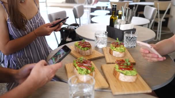 Группа друзей фотографирует еду со смартфонов . — стоковое видео