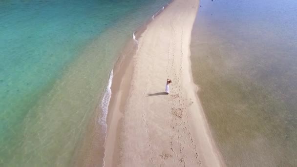 Žena v bílých šatech na pláži s otevřenou náručí. Letecký. — Stock video