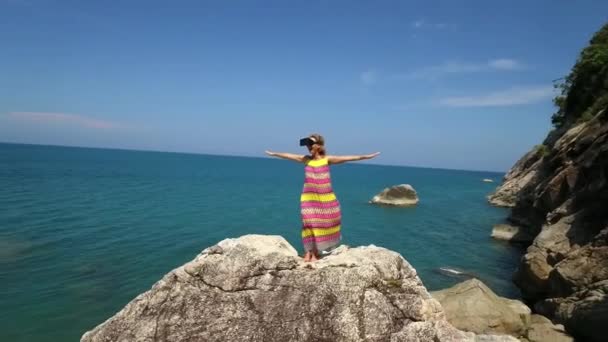 Glad kvinna i Vr glasögon på toppen av berget vid havet — Stockvideo