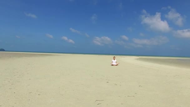 Luftaufnahmen: Yoga-Frau meditiert im Urlaub am Strand am Meer. — Stockvideo