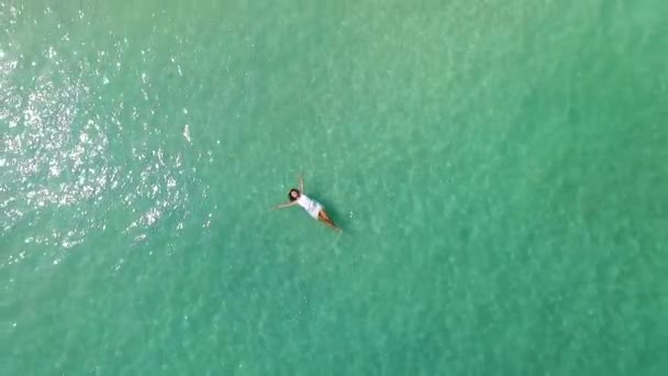 Mujer joven giratoria aérea nadando en aguas cristalinas de mar de vacaciones — Vídeos de Stock