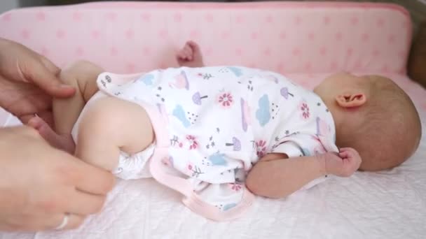 Moeder handen kleden haar baby in bodysuit — Stockvideo