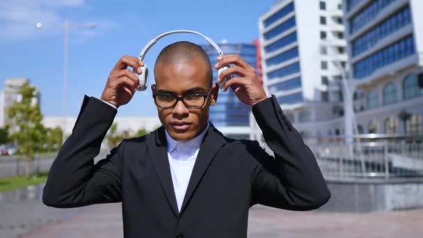 Retrato del hombre de negocios atractivo y diverso que usa auriculares inalámbricos y gafas . — Vídeos de Stock