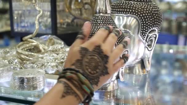 Female Hand With Mehendi Tattoo Touching Buddha Statue In Souvenir Shop — Stock Video