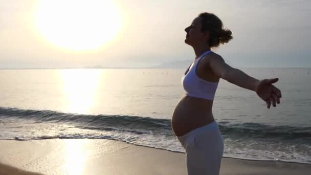 Femme enceinte avec bras ouverts sur la plage . — Video