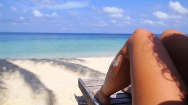 Mujer piernas tomando el sol en la playa disfrutando del mar — Vídeo de stock