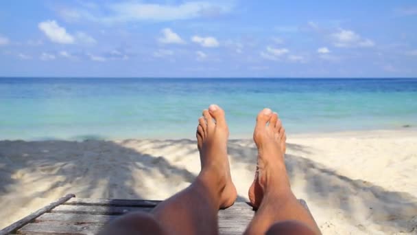 Mann Füße entspannen am Strand auf Sonnenliege im Urlaub — Stockvideo