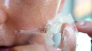 Genç bir kadın maskesini çıkarıyor.