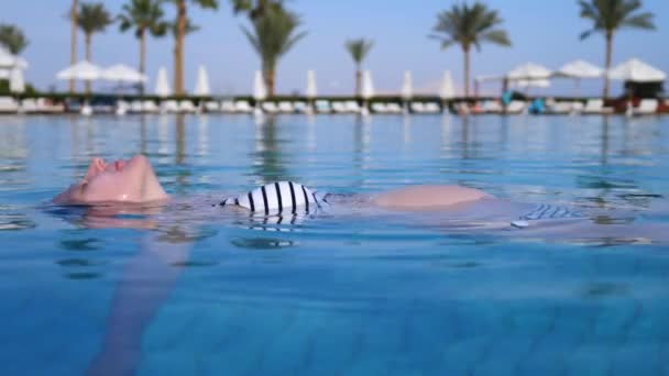 행복 한 건강 한 임신의 개념. 수영장에서 휴식을 취하는 임신부. — 비디오