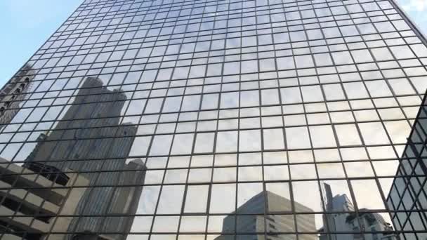 Современный небоскрёб в деловом районе против голубого неба — стоковое видео