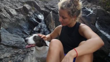 Yürüyüşten sonra Şelalede Köpekle Oturan Spor Kadını