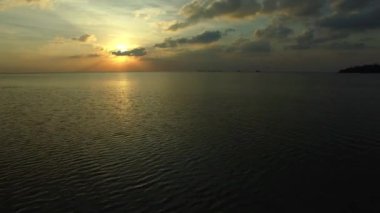 Günbatımının hava görüntüsü. Denizin üzerinde uçmak. 4k.