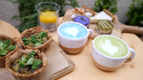 Desayunando con té verde Matcha Latte, café azul Matcha Latte y comida vegana . — Vídeos de Stock