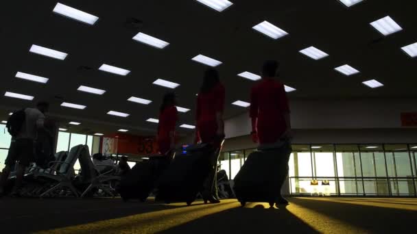 A légiutas-kísérők felszállnak a repülőtérre napkeltekor.. — Stock videók