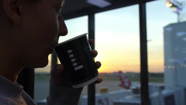 Молодая женщина пьет кофе в аэропорту — стоковое видео