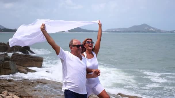 穿着白衣在海边快乐的老夫妇 — 图库视频影像