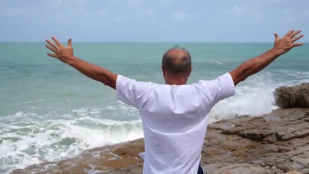 Maduro sênior homem estendendo braços no praia por mar — Vídeo de Stock