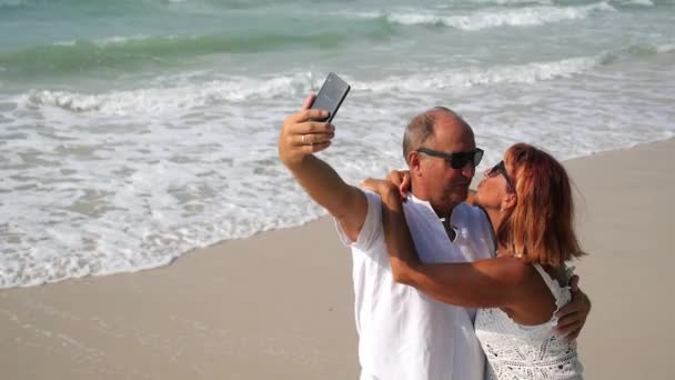 Casal Sênior em pé na praia tomando Selfie — Vídeo de Stock