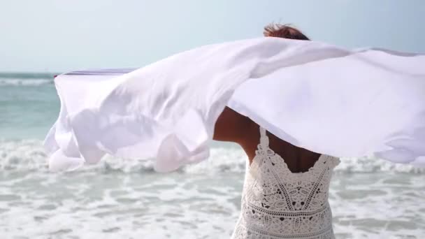 Senior vrouw met armen uitgestrekt op het strand — Stockvideo