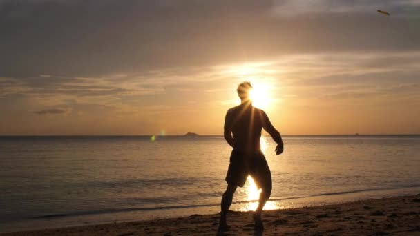 Sunset 'te plajda frizbi oynayan adamın silueti. Yavaş Hareket. — Stok video