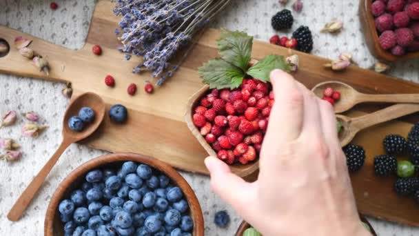 Свежие ягоды в деревянных чашах на столе. Концепция здорового питания и питания . — стоковое видео