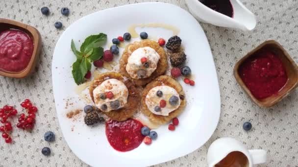 Colazione con pancake con bacche, panna acida e cannella. Vista dall'alto alla moda . — Video Stock