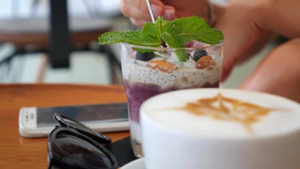 Comer pudín de chía y beber café en el café. Concepto de superalimentos — Vídeo de stock