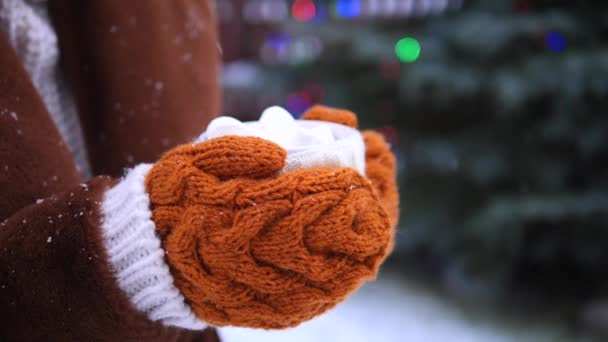 Mãos de mulher segurando copo quente com chocolate quente e marshmallow . — Vídeo de Stock