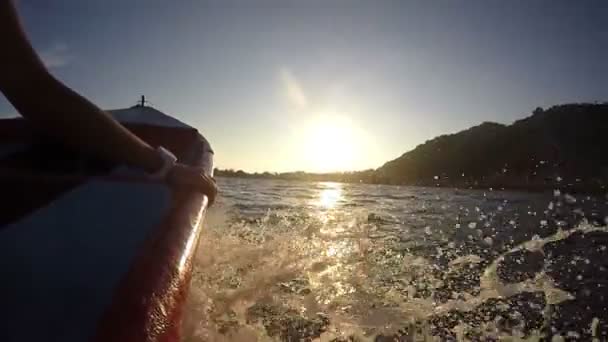 Motorboot segelt im Meer mit Spritzern bei Sonnenuntergang — Stockvideo