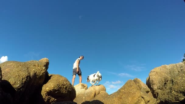 Homem feliz com cão no topo da montanha — Vídeo de Stock