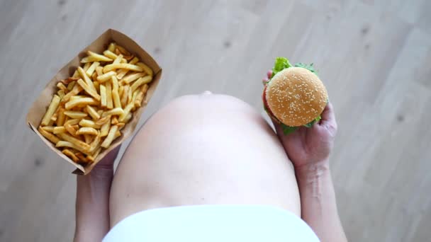 Беременная женщина ест вредную пищу. Страсть к беременности и концепция быстрого питания . — стоковое видео
