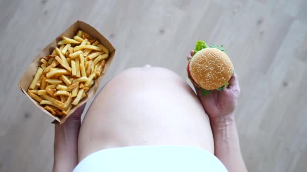 Mujer embarazada comiendo comida chatarra. Anhelo de embarazo y concepto de comida rápida . — Vídeo de stock