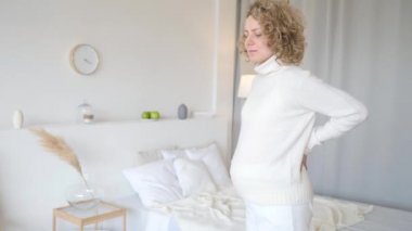 Hamilelik sırasında sorunlar ve rahatsızlık. Sırt ağrısı çeken hamile bir kadın sırtına dokunuyor..