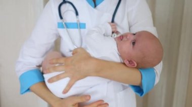 Bir doktor elinde bir bebek tutuyor..