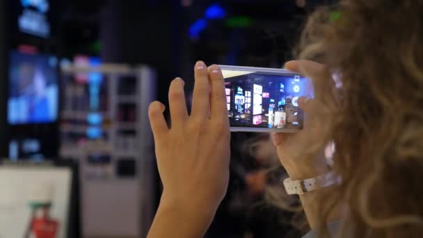 Женщина фотографируется с сотовым телефона ночного города с объявлениями светодиодных огней — стоковое видео