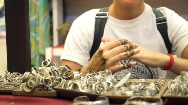 Vrouw toerist kiezen handwerk zilveren ringen tijdens het winkelen — Stockvideo