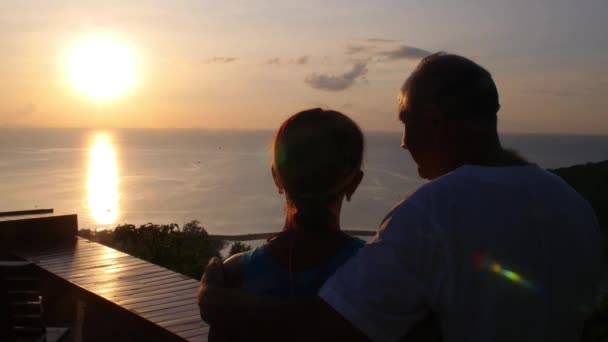 Casal sênior desfrutando do pôr do sol sobre o mar em férias de verão — Vídeo de Stock