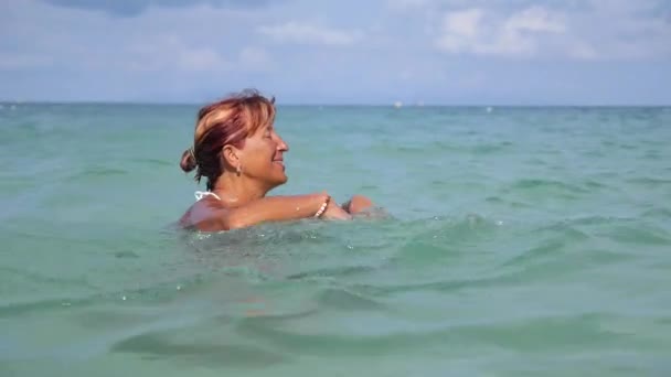 Счастливая пожилая женщина плывет в море на летних каникулах — стоковое видео