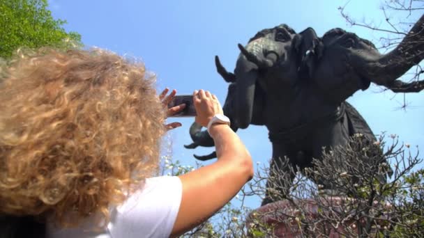 女游客拿着巨型大象雕像的手机拍照. — 图库视频影像