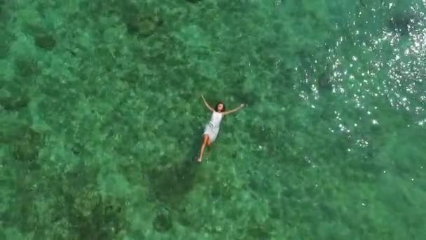 Mujer despreocupada nadando en aguas cristalinas del mar azul. Tiro aéreo . — Vídeos de Stock