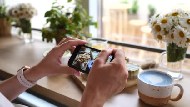 Las manos de la mujer tomando fotos de postres y café azul Matcha Latte usando Smartphone . — Vídeos de Stock