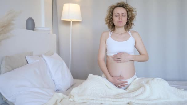 Junge schwangere Frau praktiziert Yoga und Atemübungen zu Hause. — Stockvideo