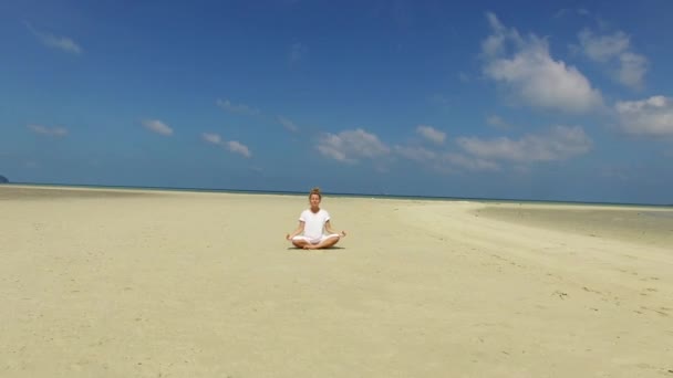 Yoga Mulher em Roupas Brancas Praticar Meditação na Praia. Vista aérea. 4K . — Vídeo de Stock