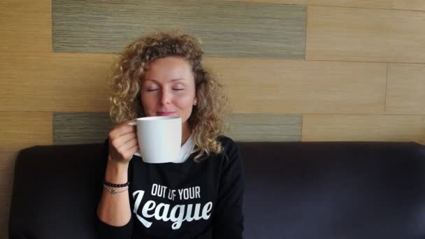 Mladá usměvavá žena s šálkem kávy — Stock video